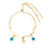 The Light Blue Evil Eye and Hamsa Hand Charms Bracelet features a 14k gold-filled adjustable snake chain link, adorned with a wavy design and three charms: two blue and black evil eye motifs alongside a central Hamsa hand symbol.